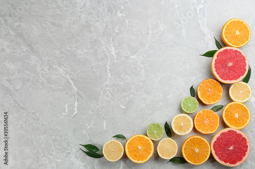 Flat lay composition with tangerines and different citrus fruits on grey marble background. Space for text © New Africa