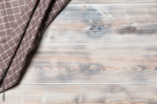 ein Geschirrtuch und ein Teller auf einem Hintergrund aus Holz im Retrostil, Aufsicht, Top View