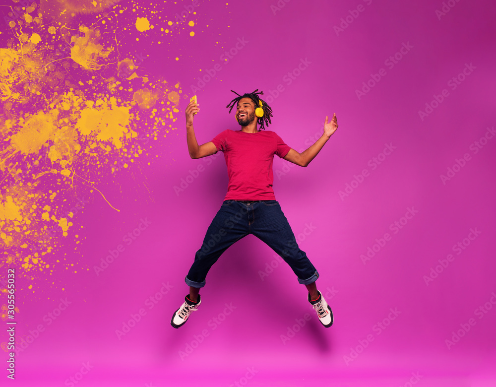 Boy with yellow headset listens to music and dances. emotional and energetic expression. Color spray effect