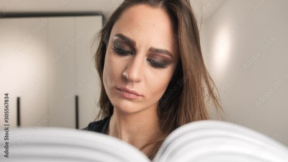 concentrated young girl reading book at home on interior background 4k concentrated young girl reading book at home on interior background 4k