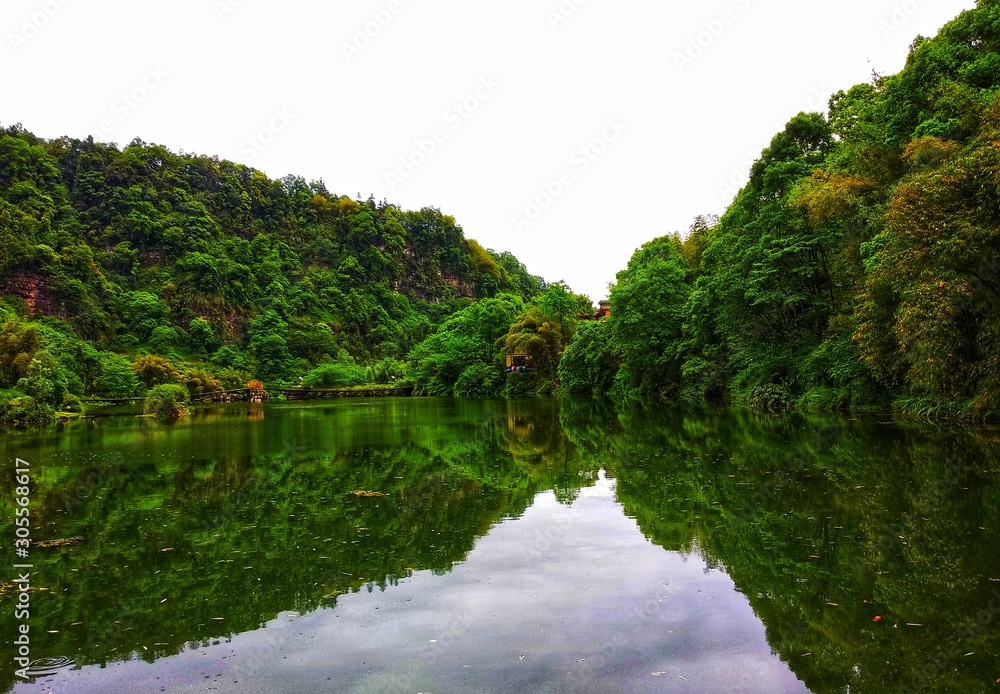 a beatiful lake with green trees and reflection in the water