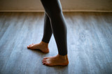 Close up rear view of womans bare feet standing in yoga pants