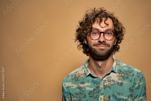 young guy with curly hair and glasses 