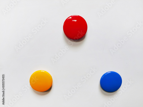 Round colored magnetic markers pinned to a white board with copy space