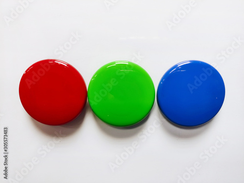 Round colored magnetic markers inline pinned to a white board close up