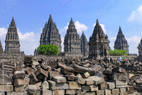 Pagodas and tourist in Prabanan Temple or Candi Prambanan against blue sky with foreground of ruin rock, the biggest ancient hindustani in Java Island, UNESCO world heritage site, Indonesia