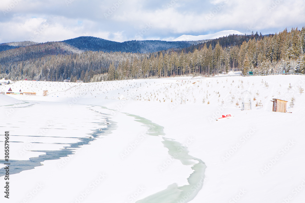 image of frozen lake and forest with fir trees