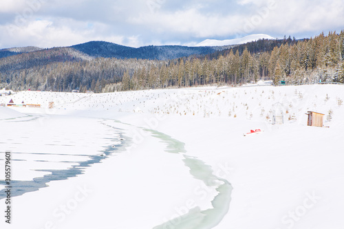 image of frozen lake and forest with fir trees