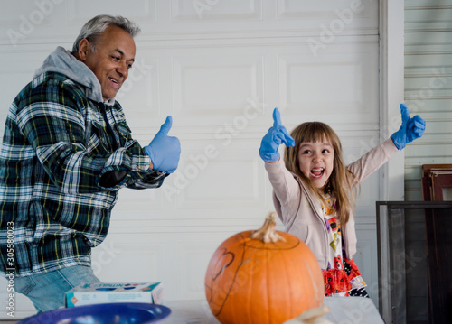 Father Daughter laughing and thumbs up with pumpkin, lifestyle photo