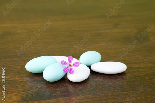 Confetti, in the foreground with a purple flower on a wooden table photo