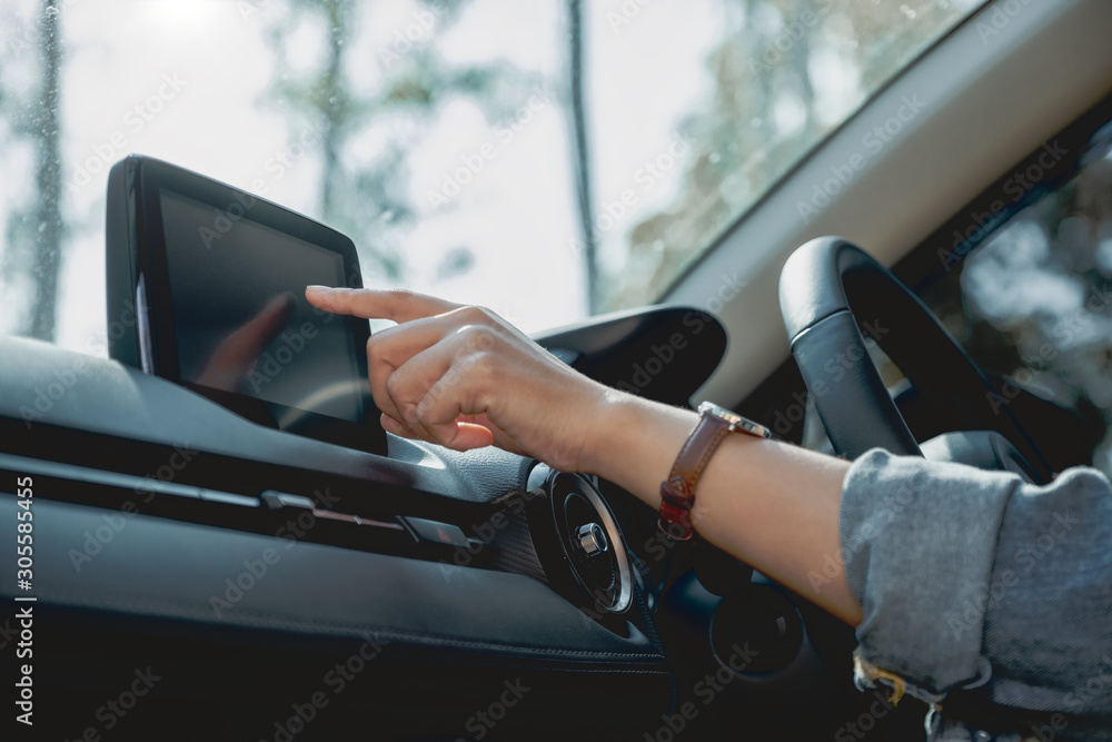 Closeup image a woman using and pointing finger at navigation screen while driving car