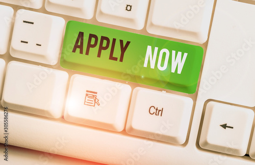 Writing note showing Apply Now. Business concept for An act of a demonstrating to acquire the job related to the profession White pc keyboard with note paper above the white background photo