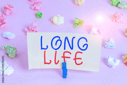 Word writing text Long Life. Business photo showcasing able to continue working for longer than others of the same kind Colored crumpled papers empty reminder pink floor background clothespin © Artur