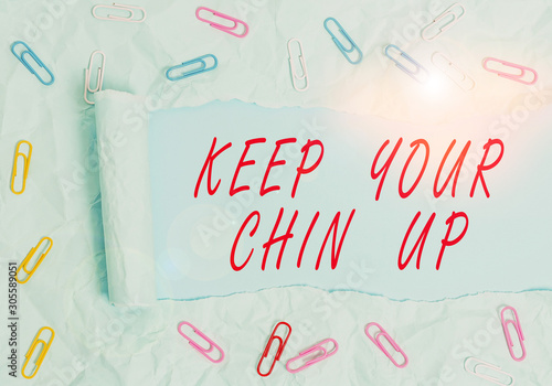 Text sign showing Keep Your Chin Up. Business photo text Remain cheerful in difficult circumstances High Spirit Paper clip and torn cardboard placed above a plain pastel table backdrop