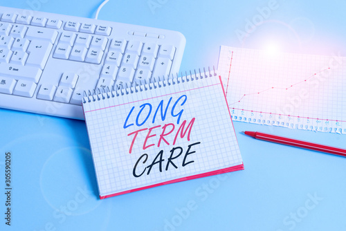 Text sign showing Long Term Care. Business photo showcasing Adult medical nursing Healthcare Elderly Retirement housing Paper blue desk computer keyboard office study notebook chart numbers memo photo