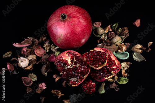 ripe pomegranate rustic style on black isolated background still life