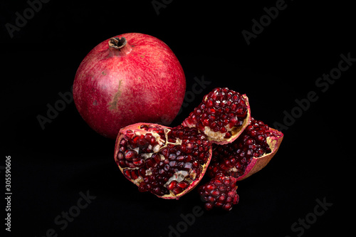 ripe pomegranate rustic style on black isolated background still life