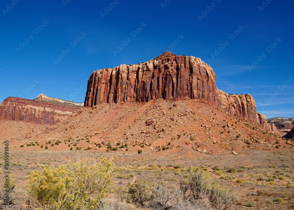 A natural red rock fortress reaches toward the brilliant blue sky in Canyonlands National Park.