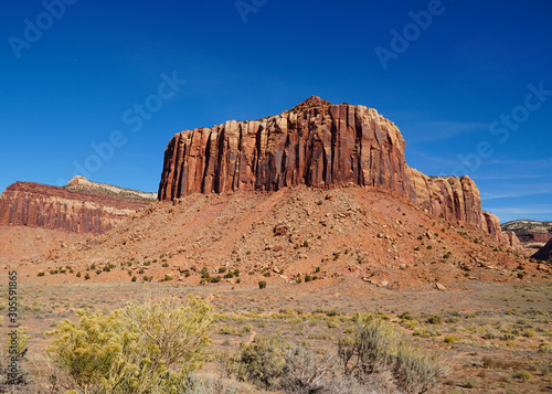A natural red rock fortress reaches toward the brilliant blue sky in Canyonlands National Park.