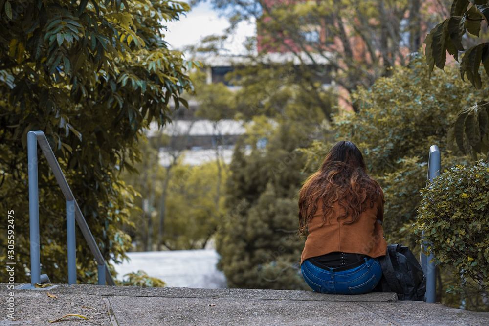young woman sitting on a bench in the park young woman sitting on a bench in the park