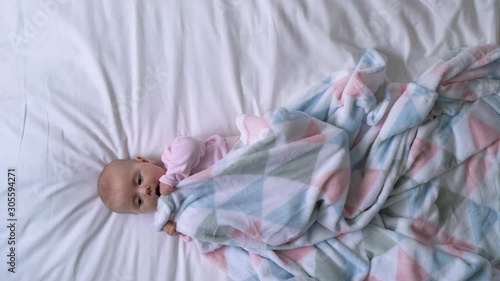 Fussy baby turning in bed and chewing blanket, colic problem, sleepless night