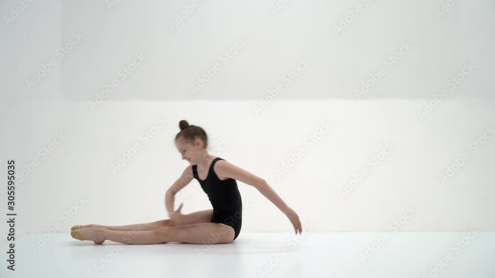 The little gymnast perform an acrobatic element on the floor. The little gymnast perform an acrobatic element on the floor.