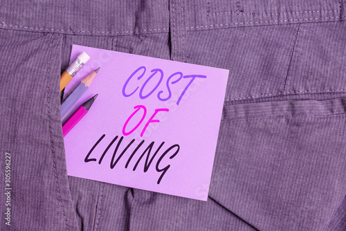 Writing note showing Cost Of Living. Business concept for The level of prices relating to a range of everyday items Writing equipment and purple note paper inside pocket of trousers