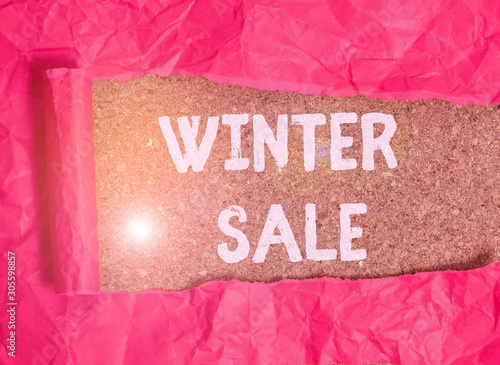 Handwriting text Winter Sale. Conceptual photo Discounts offered at the end of year Holiday sales lower prices Cardboard which is torn in the middle placed above a wooden classic table