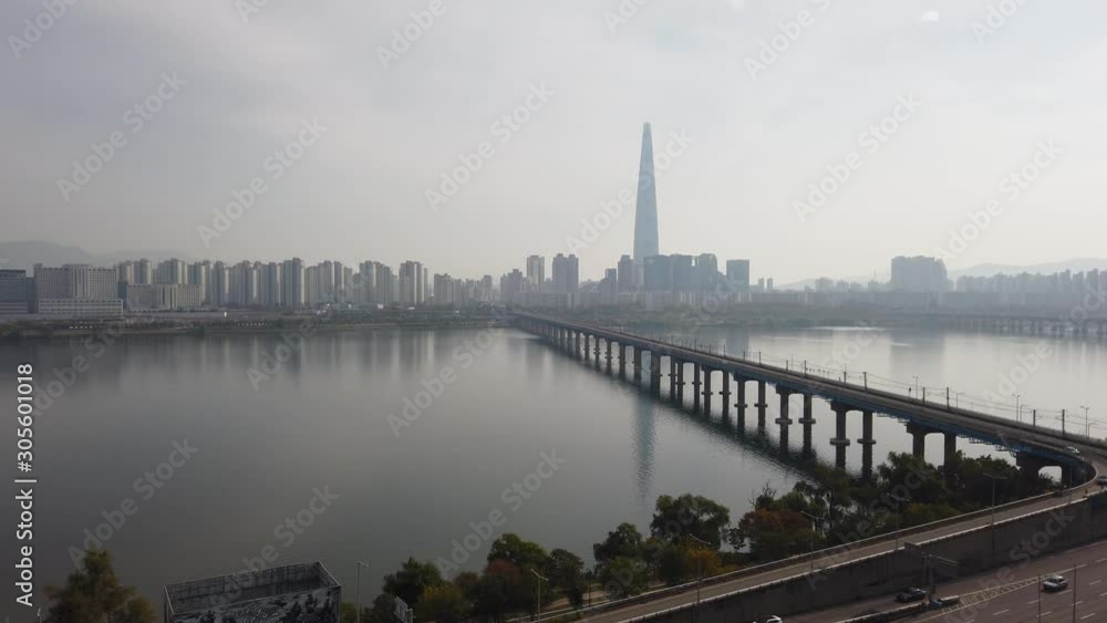 View of Seoul, South Korea featuring Han River, Lotte World Tower, Jamsil Railway Bridge and motorway in beautiful moody light and reflections. Locked off wide angle shot View of Seoul, South Korea featuring Han River, Lotte World Tower, Jamsil Railway Bridge and motorway in beautiful moody light and reflections. Locked off wide angle shot