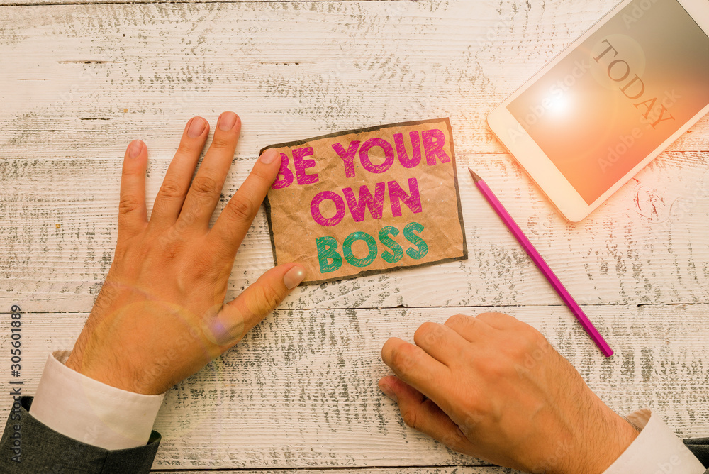 Obraz premium Text sign showing Be Your Own Boss. Business photo text Entrepreneurship Start business Independence Selfemployed Hand hold note paper near writing equipment and modern smartphone device