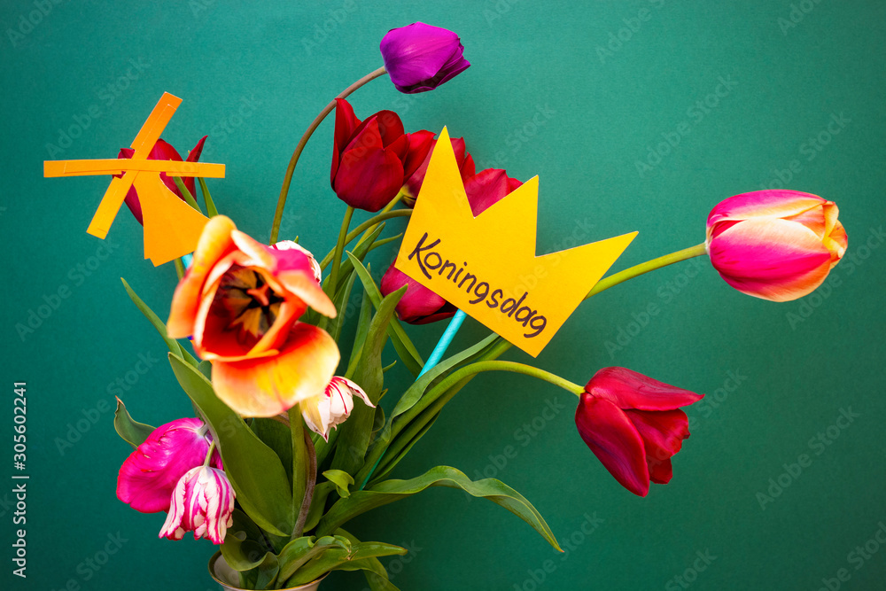 Koningsdag or King's Day is a national holiday in the Kingdom of the Netherlands. A paper-cut crown with the words Koningsdag stands in a vase with tulips