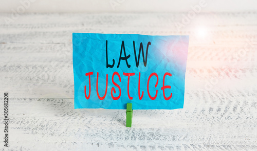 Word writing text Law Justice. Business photo showcasing a scheme or system of law in which every demonstrating receives Green clothespin white wood background colored paper reminder office supply