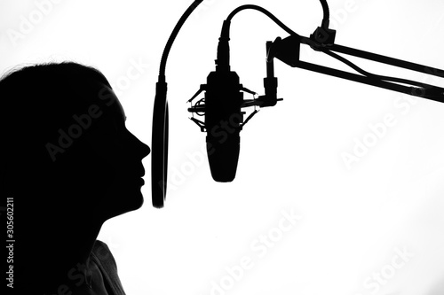 Silhouette of a girl with a studio microphone  radio presenter  singer and blogger  voice acting