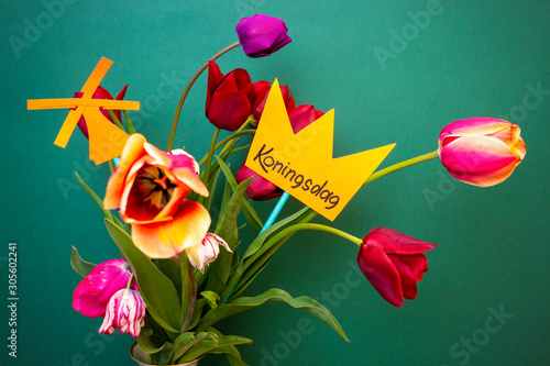 Obraz na płótnie Koningsdag or King's Day is a national holiday in the Kingdom of the Netherlands. A paper-cut crown with the words Koningsdag stands in a vase with tulips w salonie