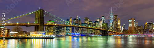 Panorama of beautiful sence of New York city with Brooklyn bridge and lower Manhattan in dusk evening. Downtown of lower Manhattan of New York city and Smooth Hudson river at night