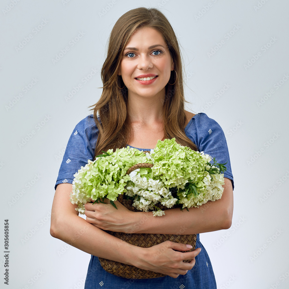 smiling woman holding straw bag with flowers. smiling woman holding straw bag with flowers.