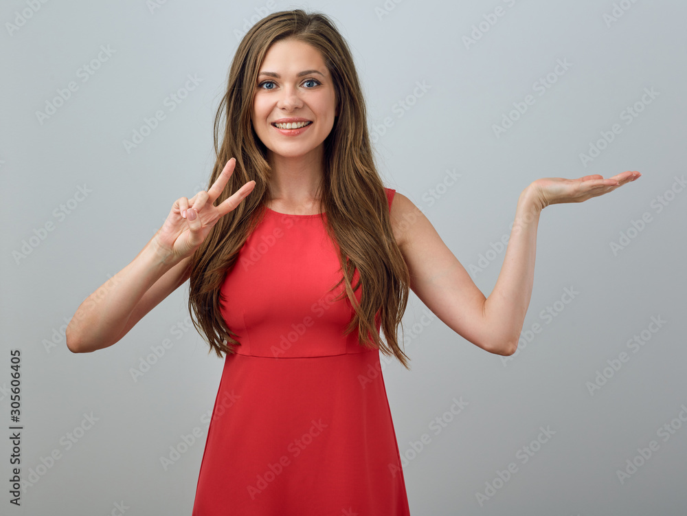 Young woman in red dress holding empty hand and showing two fingers Young woman in red dress holding empty hand and showing two fingers