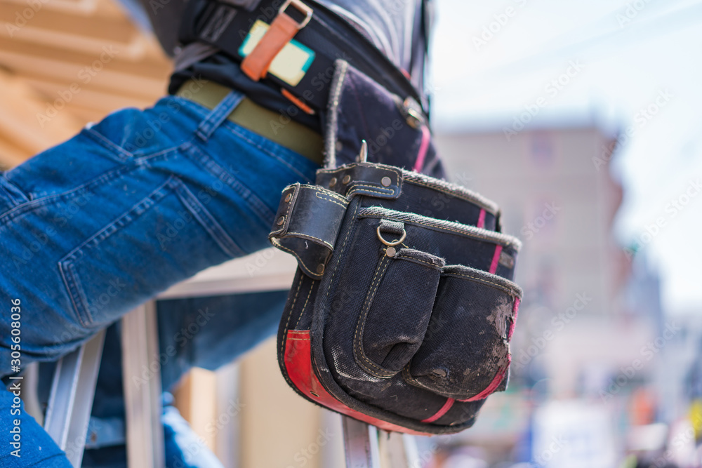 Close-up of construction worker with tool bag in leather belt Close-up of construction worker with tool bag in leather belt