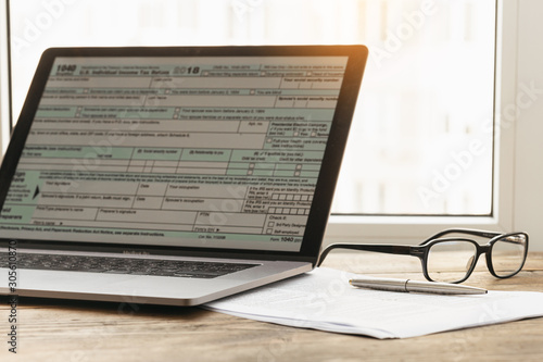 Tax planning. Laptop with form individual income tax returns