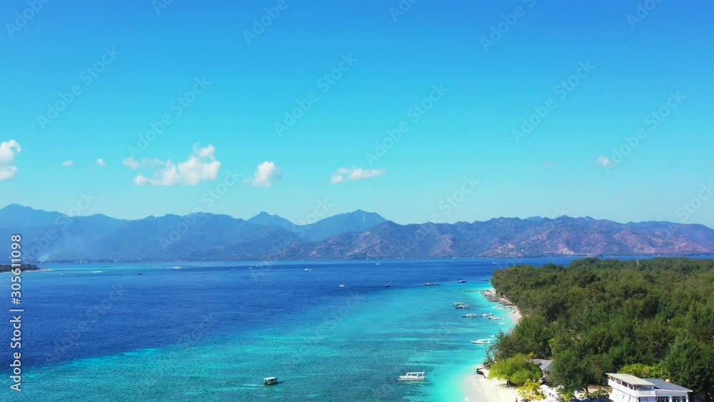 Gili Islands In Indonesia - Calm And Azure Sea Water Surrounding The Lush Island With Beautiful Scenery Of Mountains And Blue Sky - Perfect Tourist Destination - Wide Shot Gili Islands In Indonesia - Calm And Azure Sea Water Surrounding The Lush Island With Beautiful Scenery Of Mountains And Blue Sky - Perfect Tourist Destination - Wide Shot