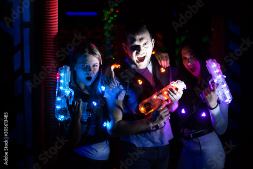 Friends with laser guns in lasertag room