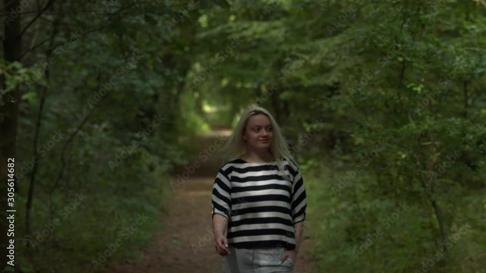 Pretty woman taking walk through the forest in spring,slow motion Pretty woman taking walk through the forest in spring,slow motion