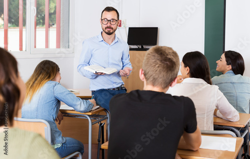 Male teacher giving lecture for students