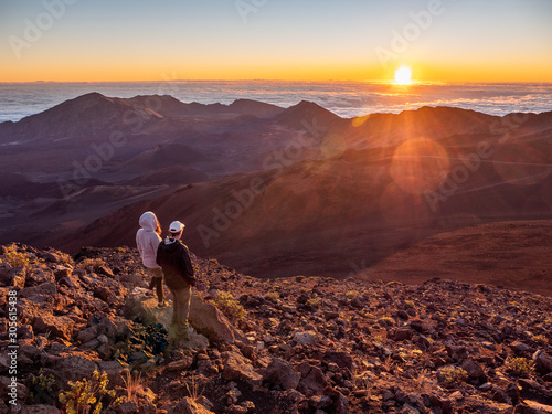Man and woman couple checking out the sunrise at Haleakala  National Park in Maui, Hawaii.
