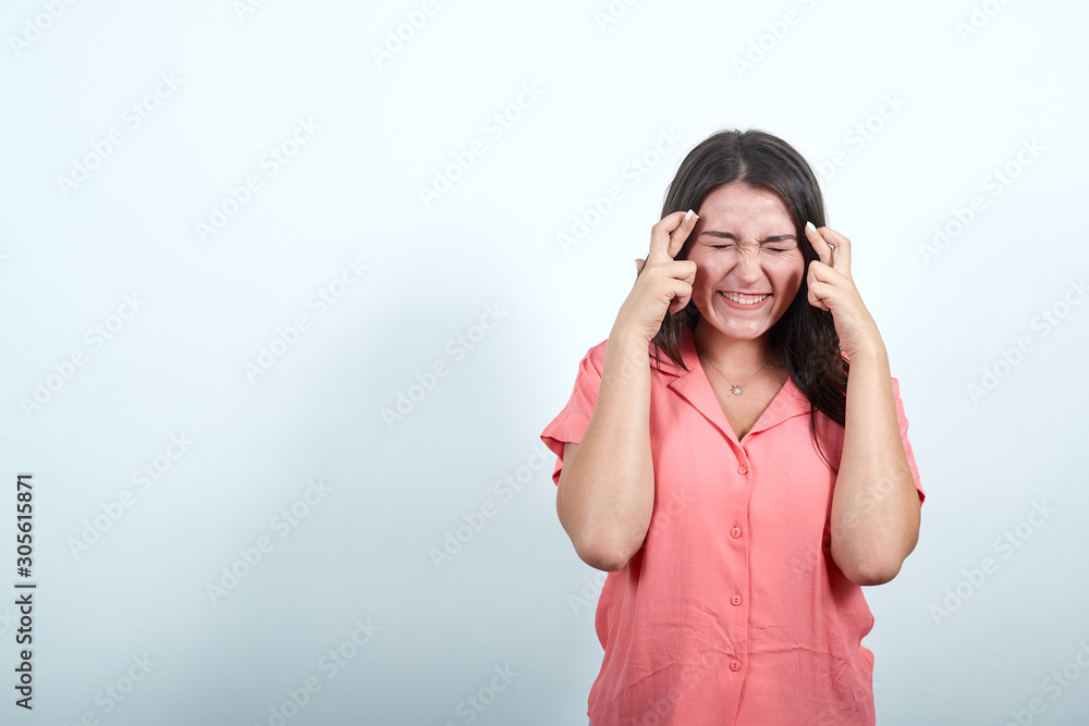 Attractive caucasian young woman in pink shirt keeping hand on crossed, waiting for special moment isolated on white background in studio. People sincere emotions, lifestyle concept. Attractive caucasian young woman in pink shirt keeping hand on crossed, waiting for special moment isolated on white background in studio. People sincere emotions, lifestyle concept.