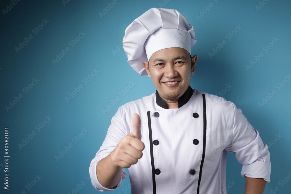 Asian Chef Smiling at Camera and Shows Thumbs Up Gesture Asian Chef Smiling at Camera and Shows Thumbs Up Gesture