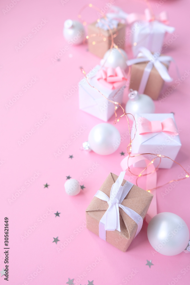 Christmas background with decorations and gift boxes on pink background
