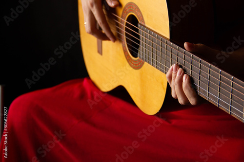 female hands hold an acoustic guitar. play music.