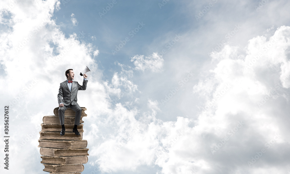 Businessman floating in blue sky and announcing something in loudspeaker