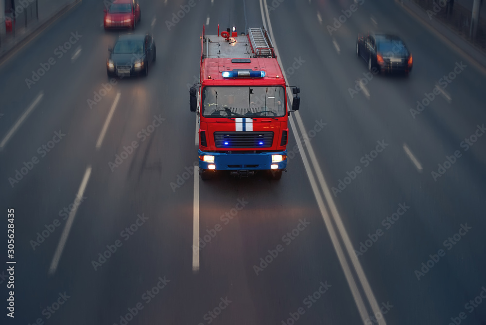 Red fire rescue truck with ladder moving on high speed on the road ...